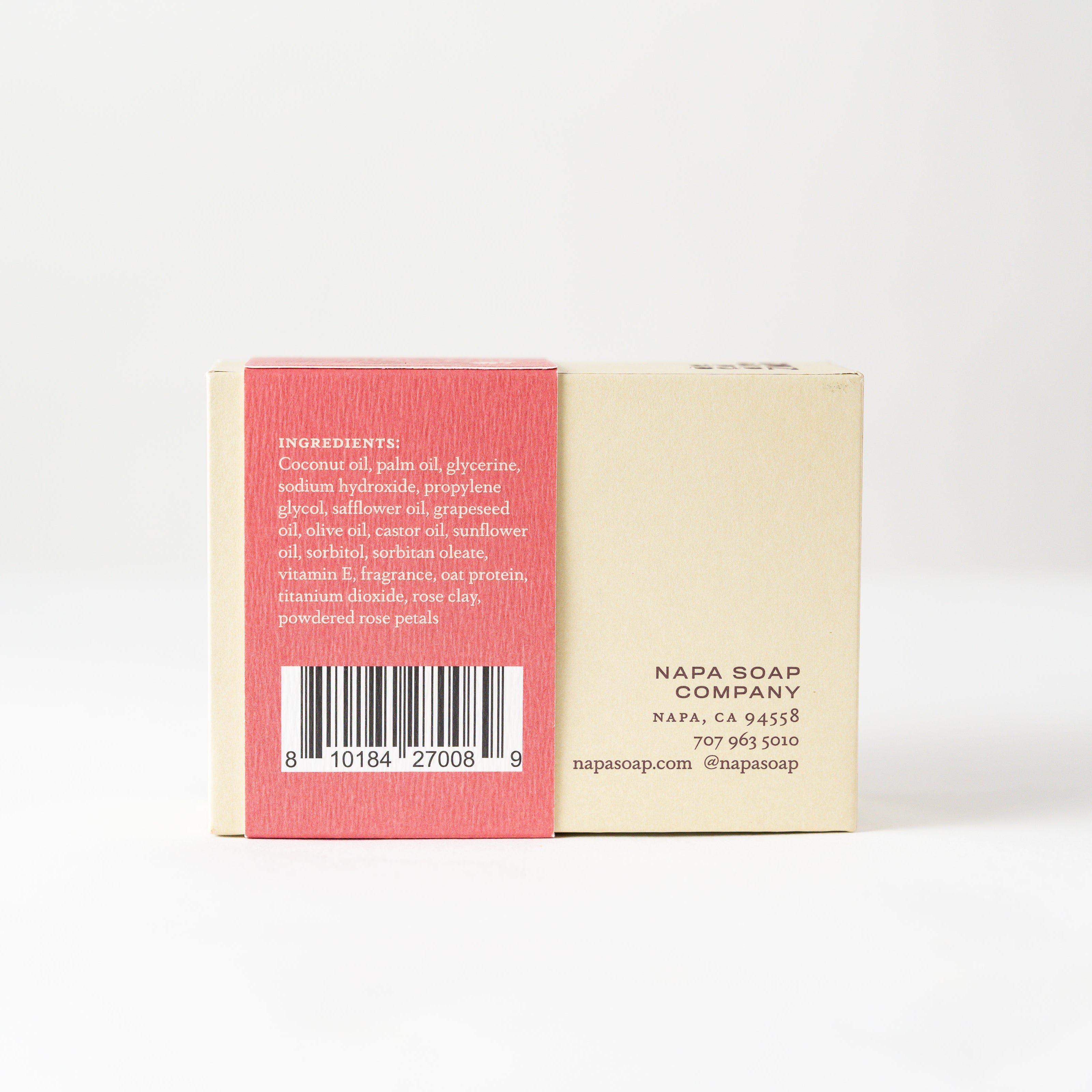 Back view of a soap bar with pink and beige label on a white background