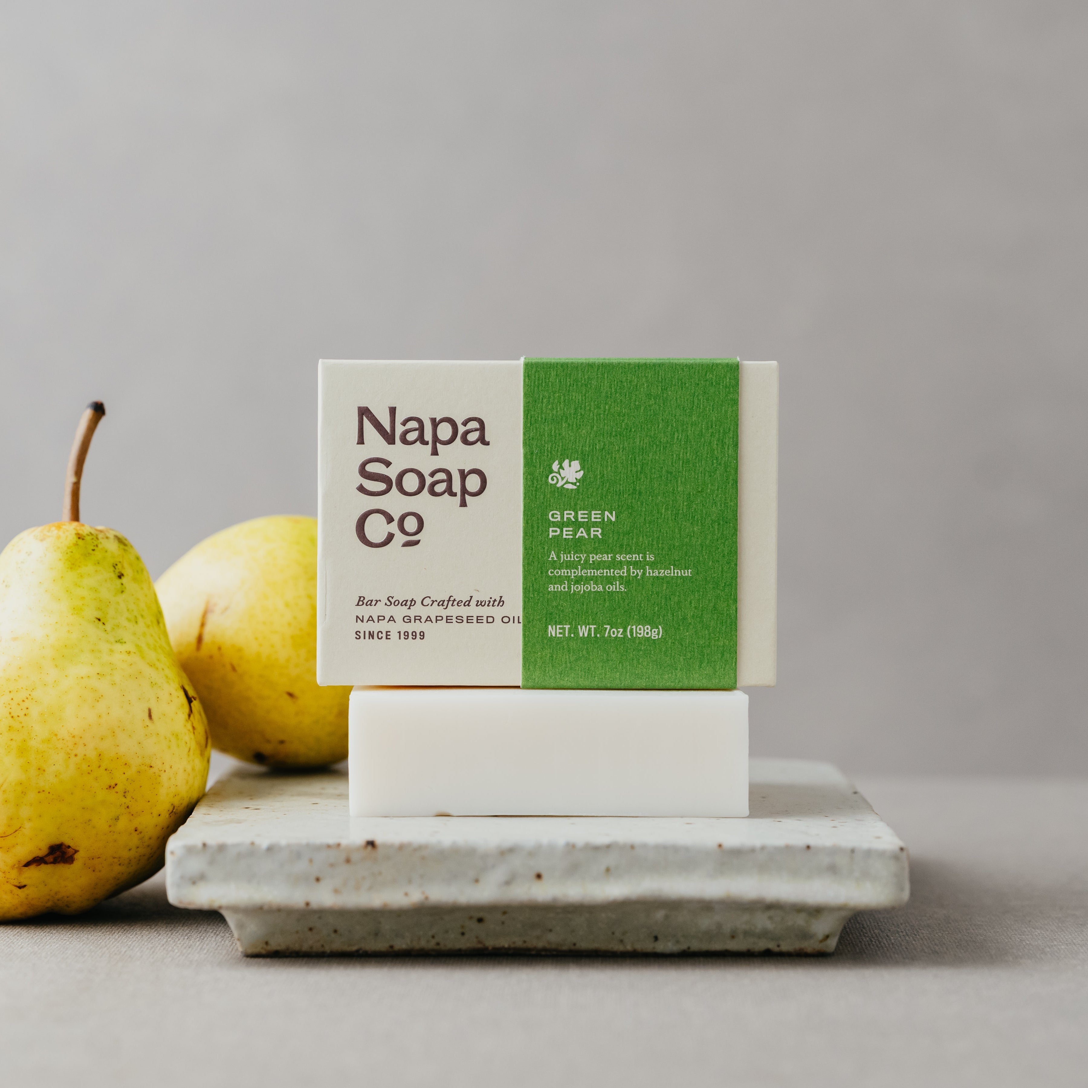 Napa Soap Co bar soap on a stand with pears on a gray background