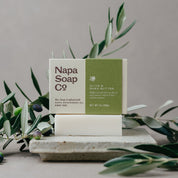 Napa Soap Co. bar of soap with olives and olive leaves on a neutral background