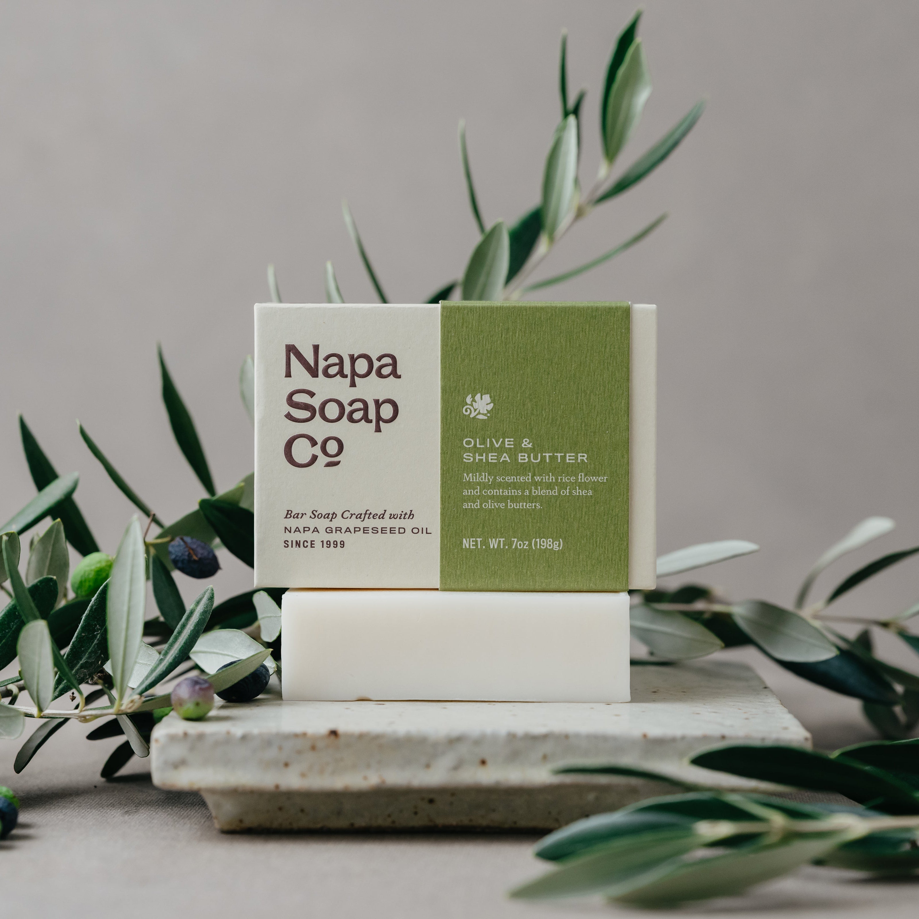 Napa Soap Co. bar of soap with olives and olive leaves on a neutral background