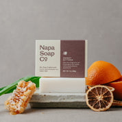 Napa Soap Co bar soap with oranges, aloe vera, and honeycomb on a gray background