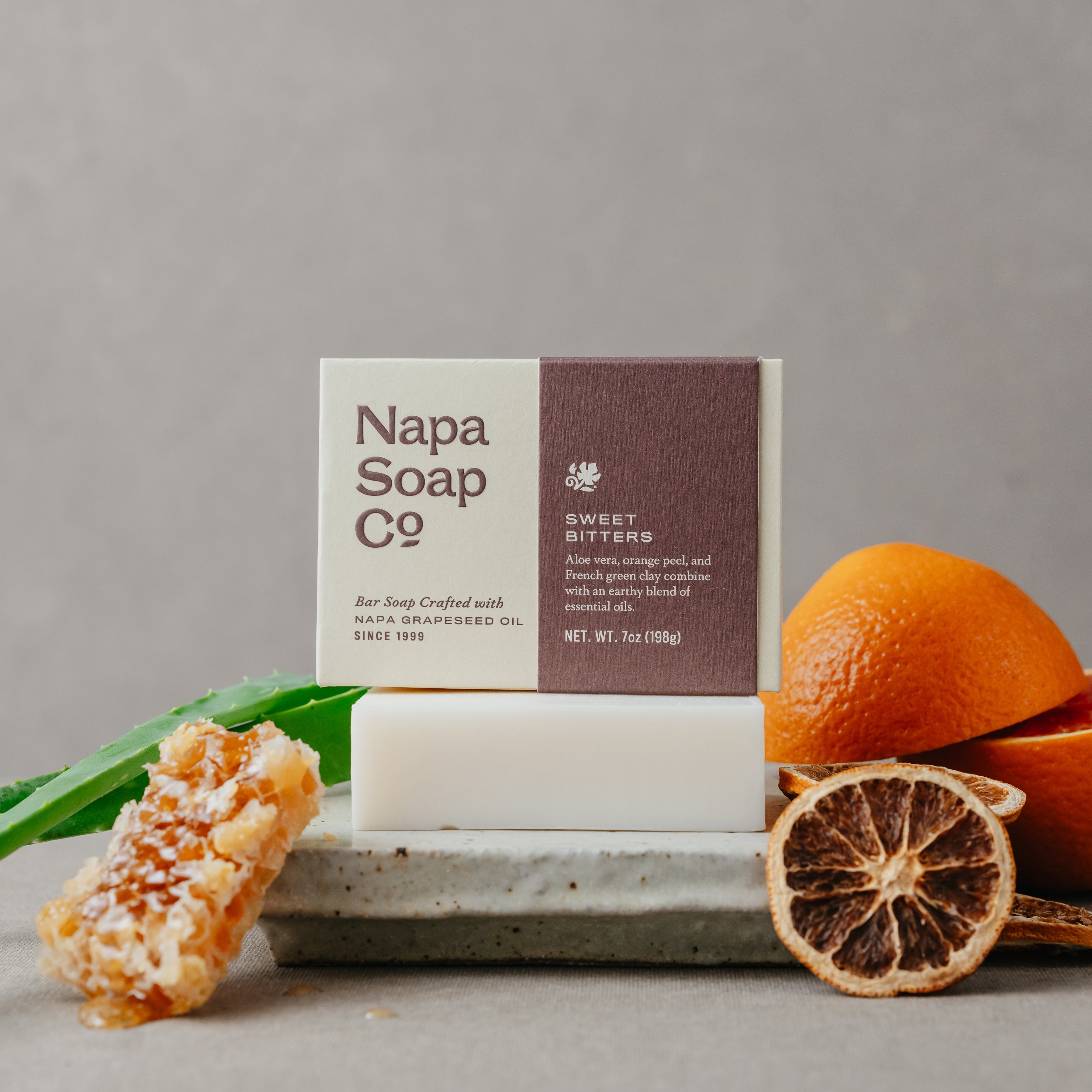 Napa Soap Co bar soap with oranges, aloe vera, and honeycomb on a gray background